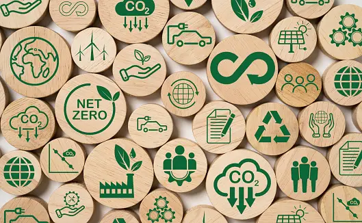 Wooden counters with green symbols showing sustainability ideas